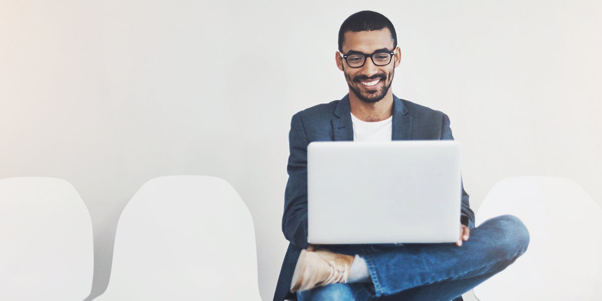 Man sitting on chair looking at laptop