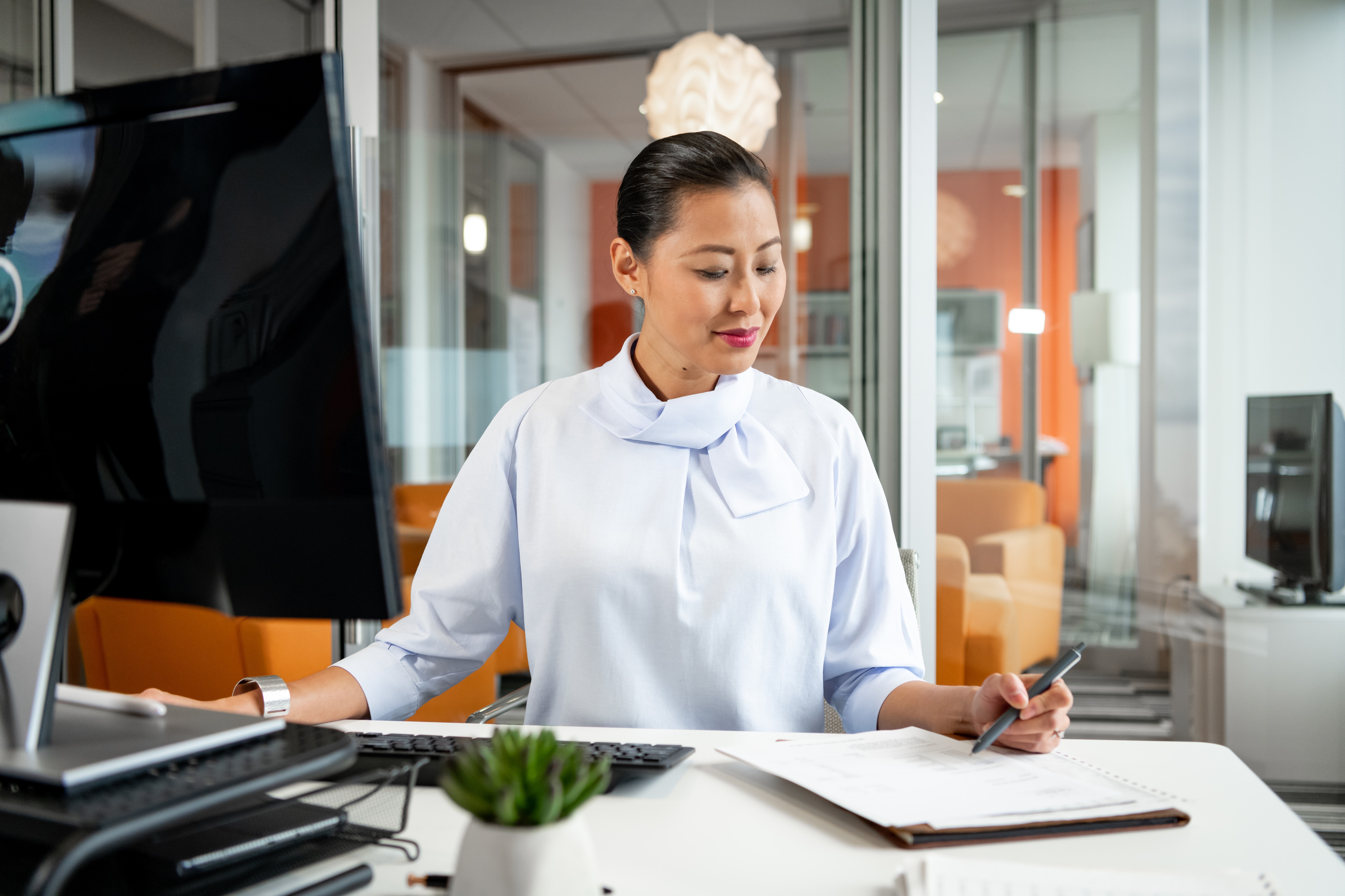 Woman working in her home office reading on her laptop