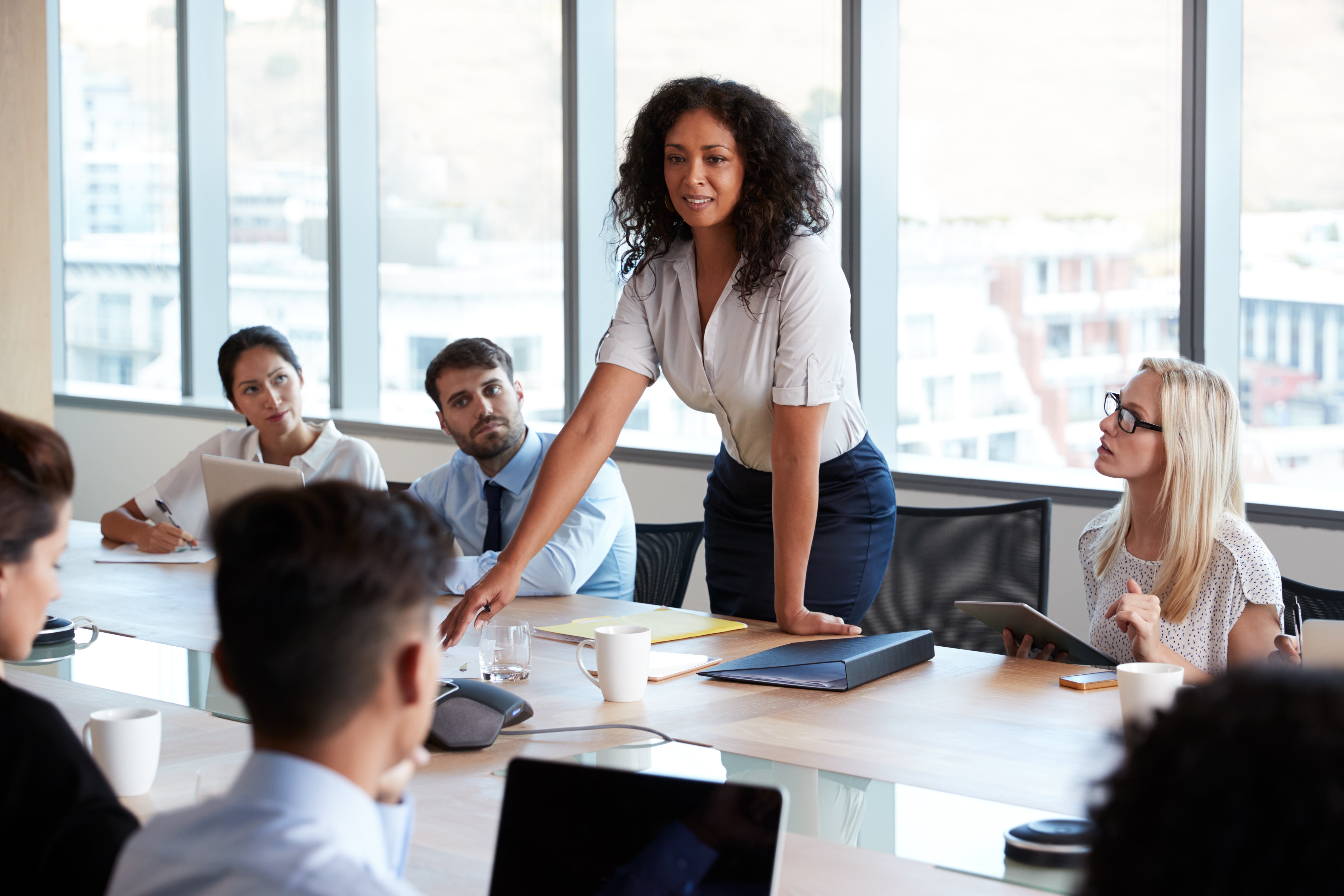 Woman standing in a meeting room with other coworkers