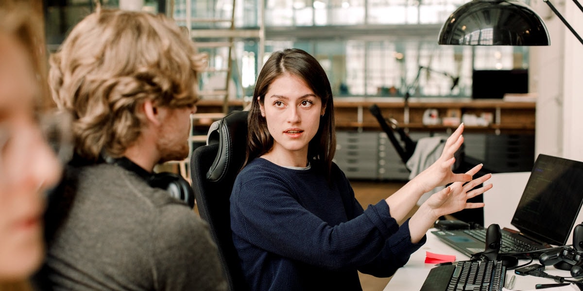 Man and woman talking near computer