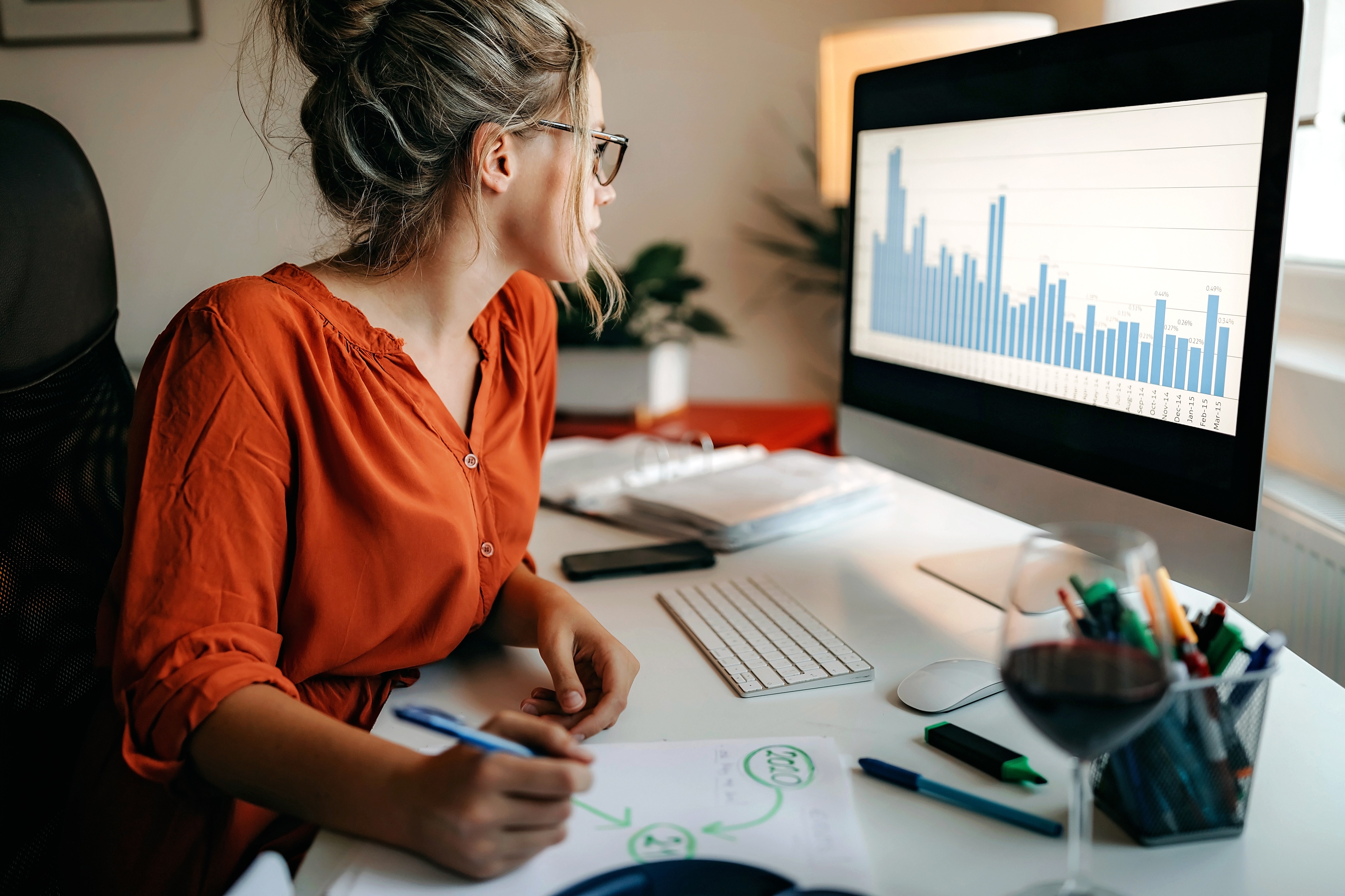 Woman at desk with computer reviewing data