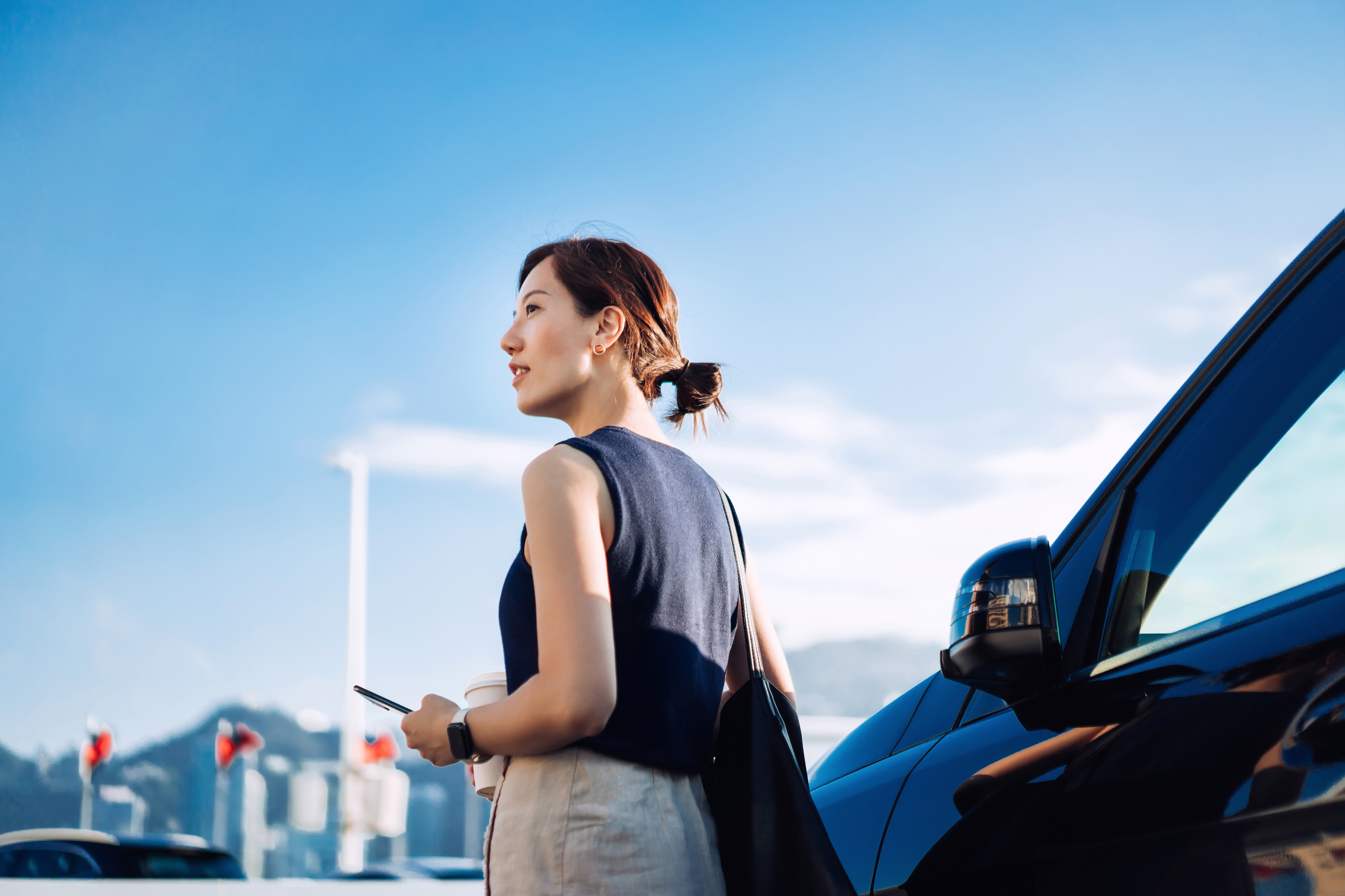woman smiling standing in front of a car