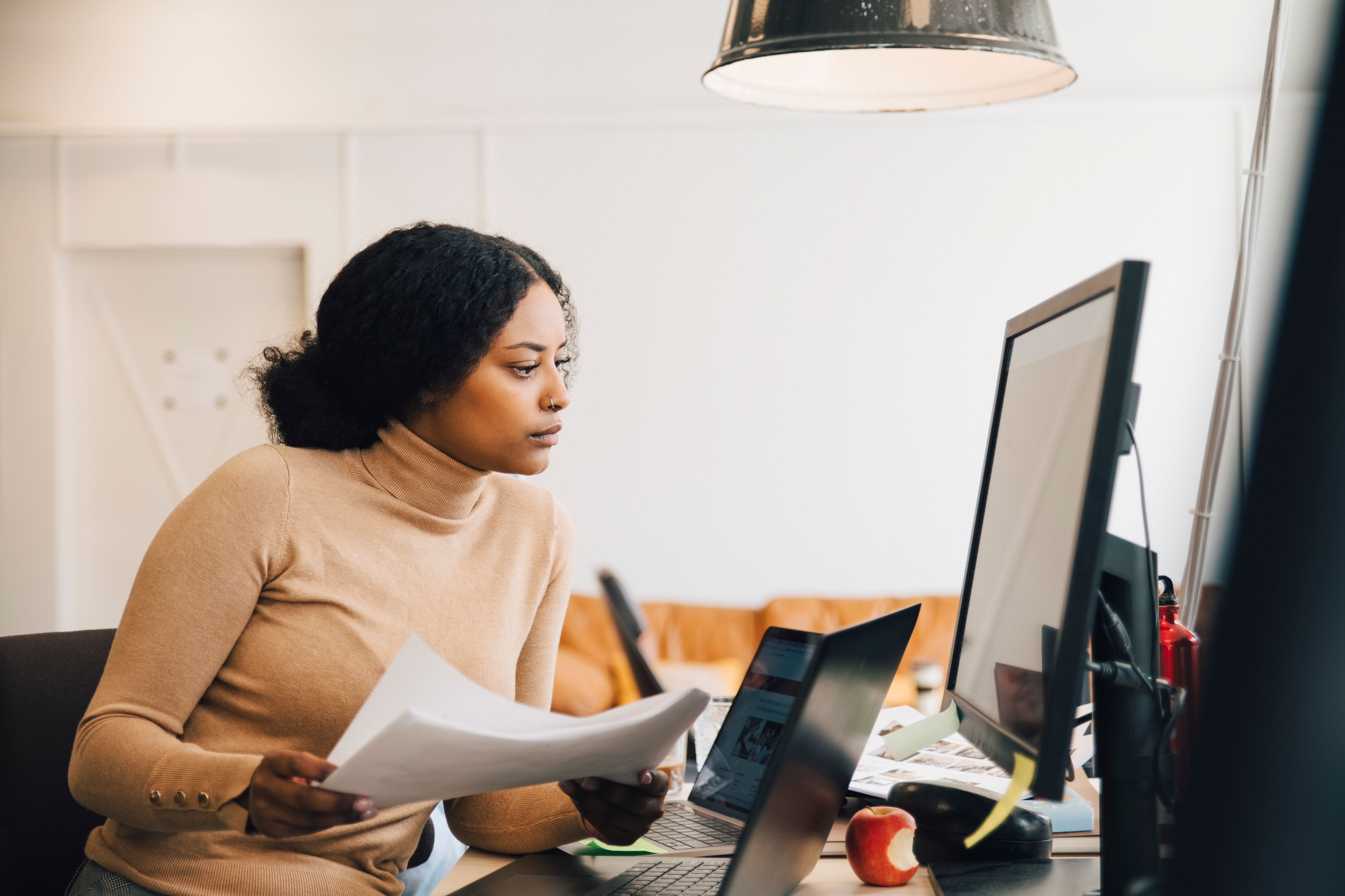 Woman at desk with computer reviewing documents