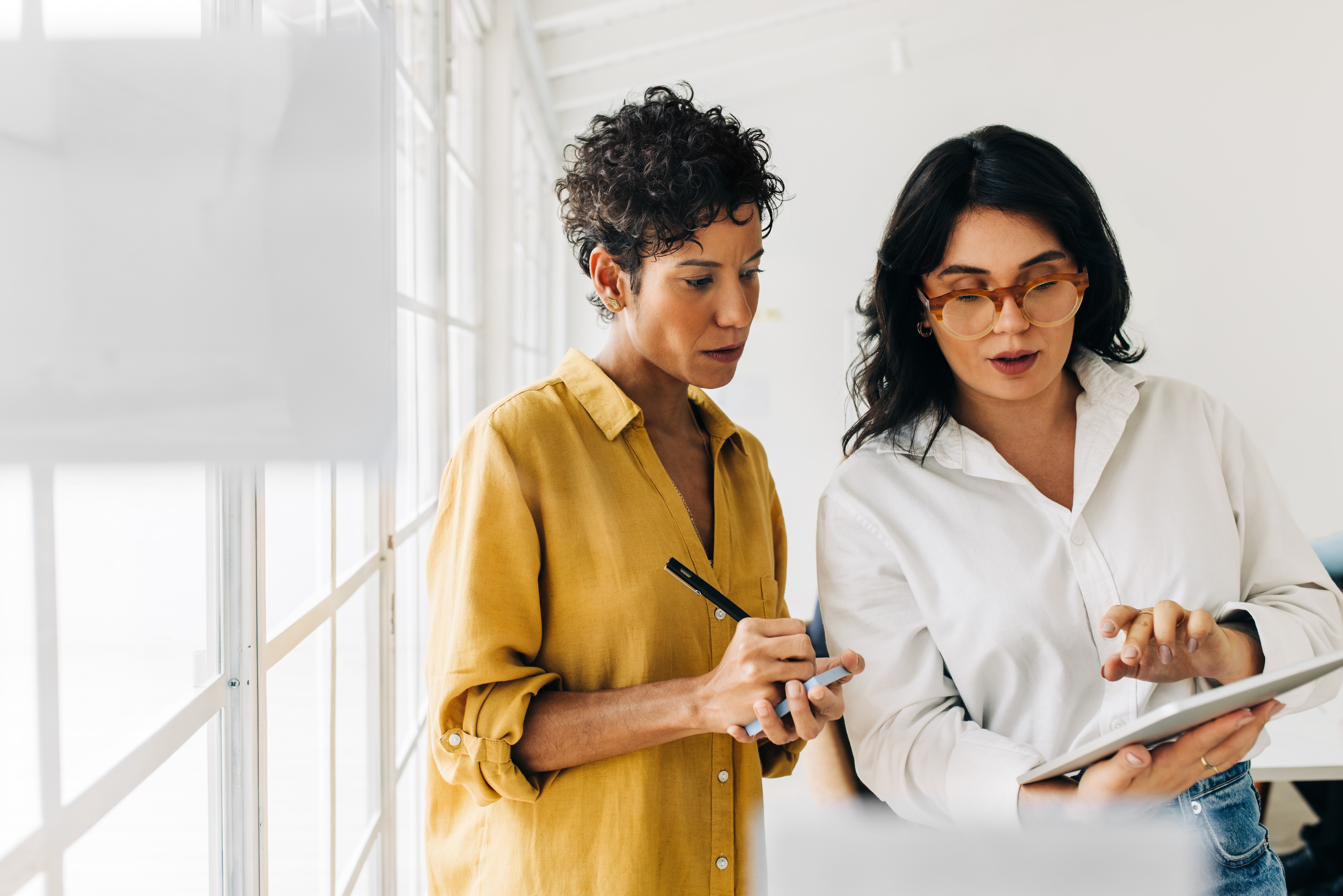 2 women looking at the ipad and having a discussion